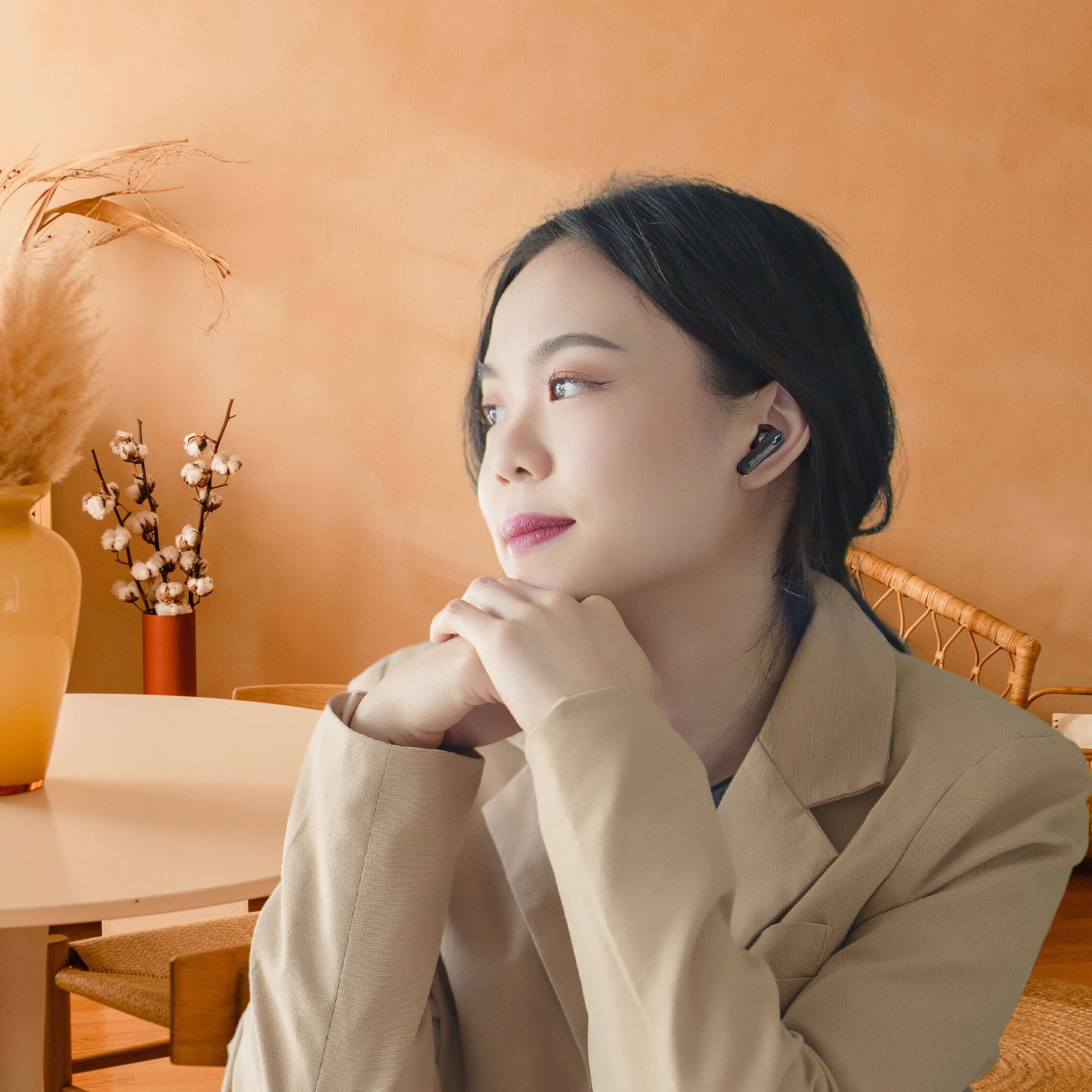 Shibela PureSound headphones worn by a woman, enjoying a moment of tranquility in a stylish room.