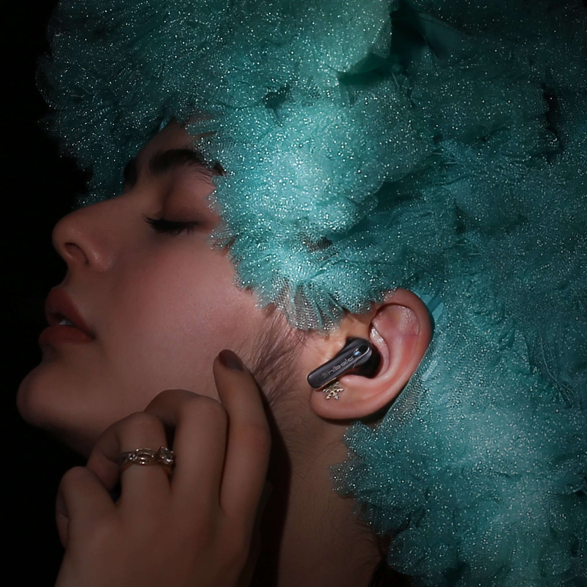 A close-up of a woman wearing Shibela PureSound headphones, showcasing her stylish hairstyle and elegant ear accessories.